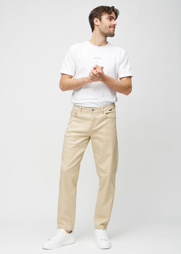 Fuldt billede af model i beige regular jeans.