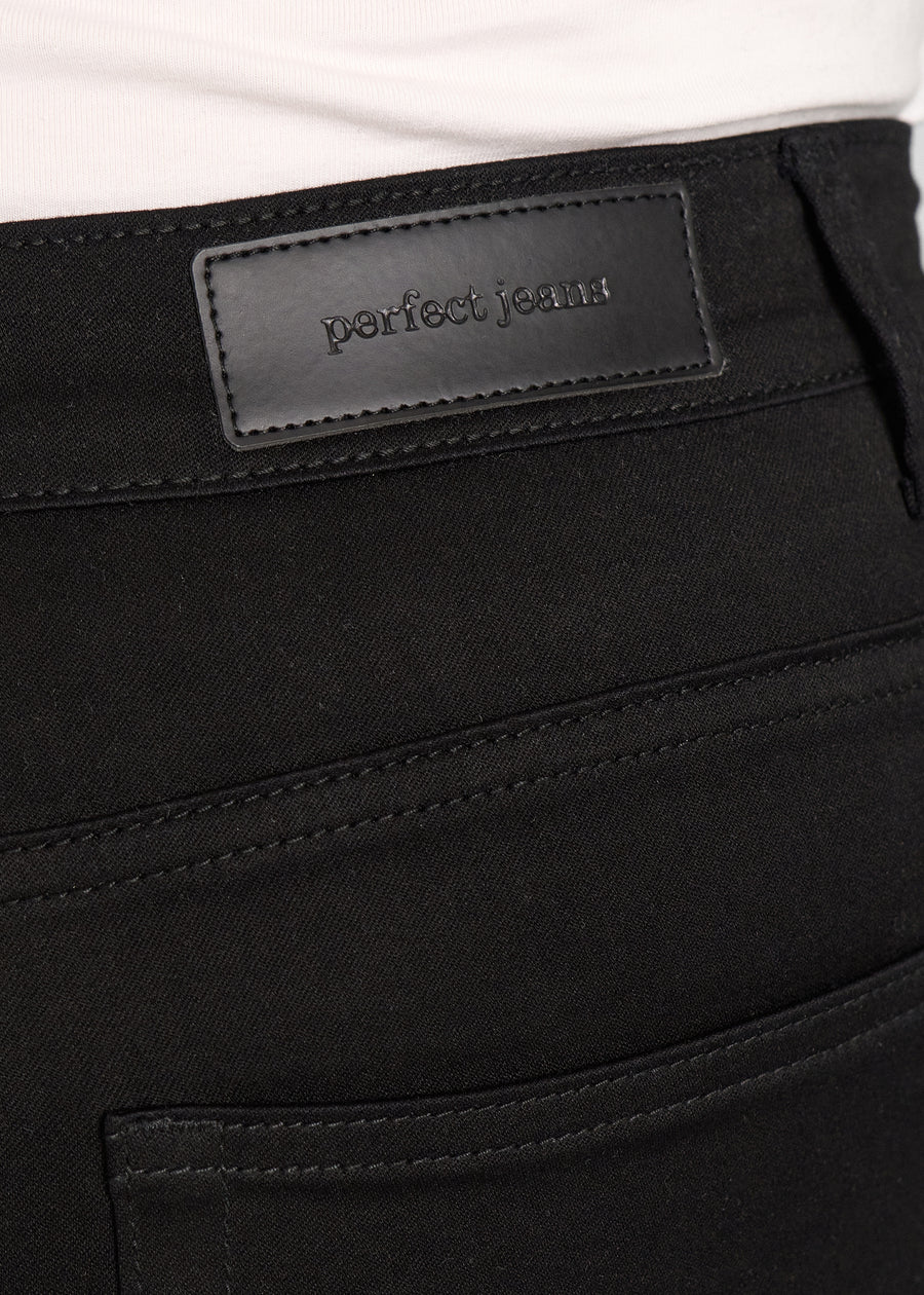 Baglommen på et par sort jeans, hvor man kan se logoet. på en plus-size model.