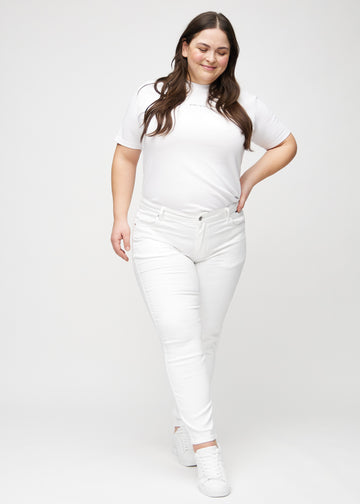 Plus-size model går ind i billedet, strækker i jeansene, viser dem frem ved at dreje rundt, og forlader derefter billedet.
