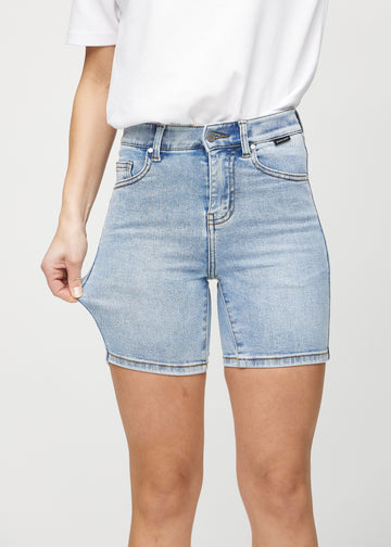 Model strækker shortsene ved låret for at vise stretch.