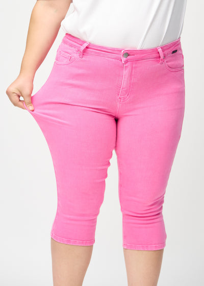 Plus-size model strækker caprisene ved låret for at vise stretch.