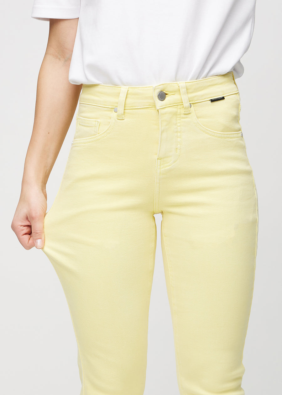 Model strækker jeansene ved låret for at vise stretch.