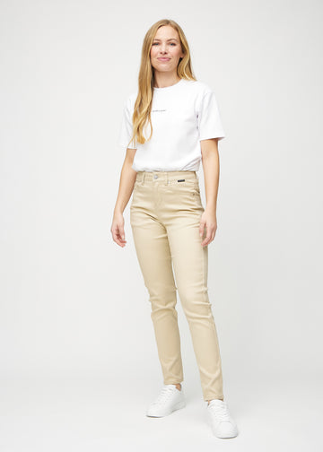 Fuldt billede af model i beige slim jeans.