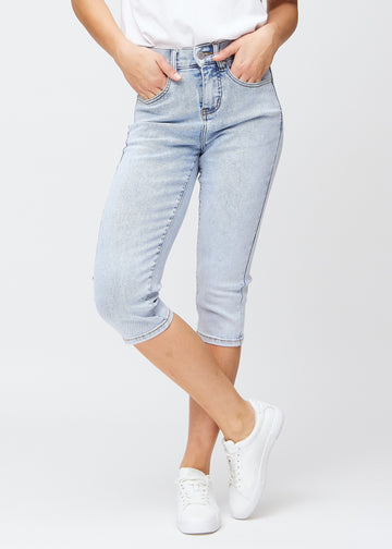 Lyseblå denim slim capris, farve Waves, med tætsiddende pasform der former benene og slutter lige under knæet – set forfra.