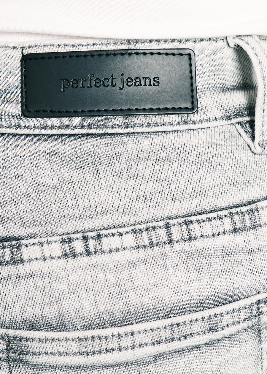 Nærbillede af lysegrå denim med Perfect Jeans læderpatch bagpå i taljen.