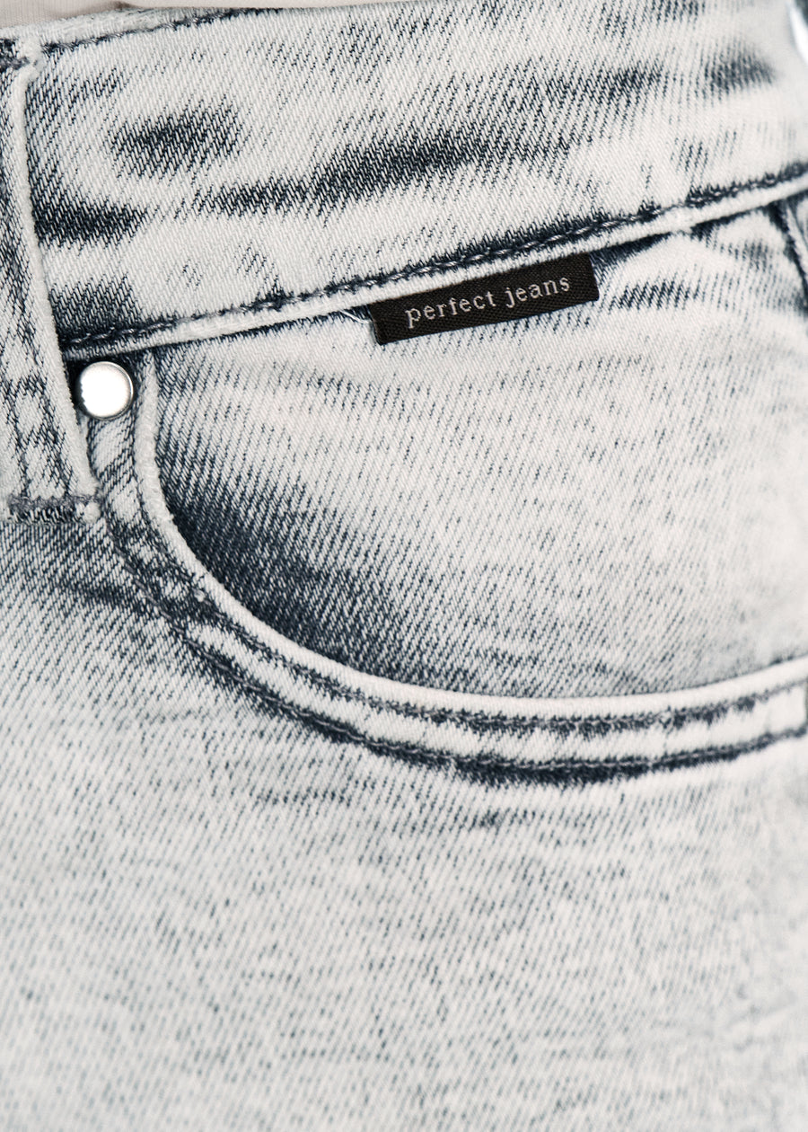 Nærbillede af lysegrå denim med Perfect Jeans logoetiket ved forlommekanten, på en plus-size model.