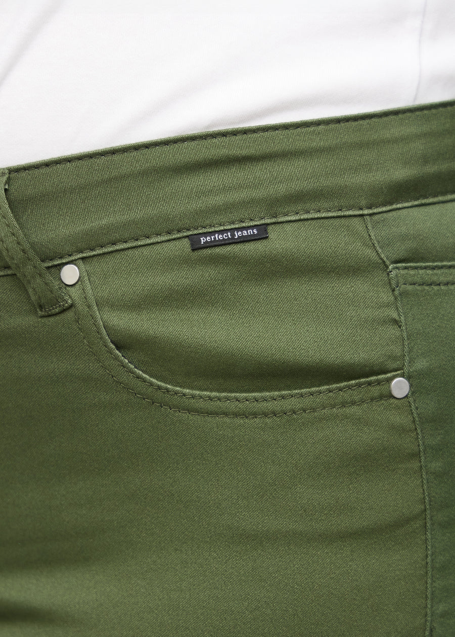 Nærbillede af grønt jeansmateriale med Perfect Jeans logoetiket ved forlommekanten, på en plus-size model.