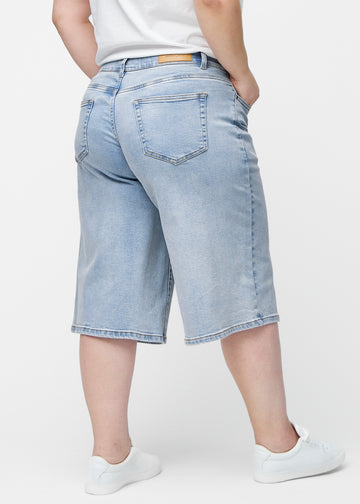 Løse, lyseblå denim capris i farven Waves set bagfra på plus-size model, så pasform og længde kan ses.