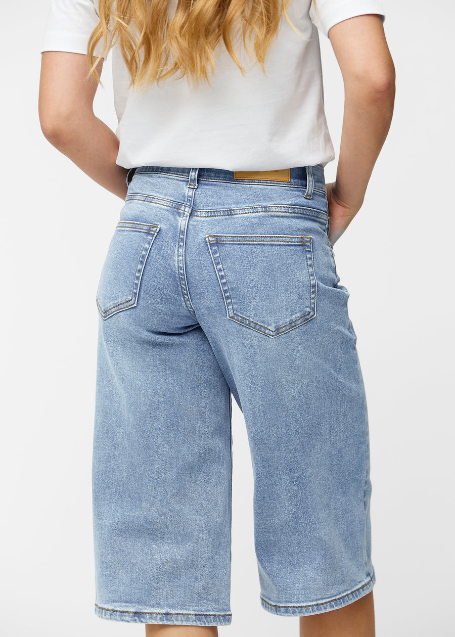 Løse, lyseblå denim capris i farven Waves set bagfra tæt på for at vise pasform og detaljer.