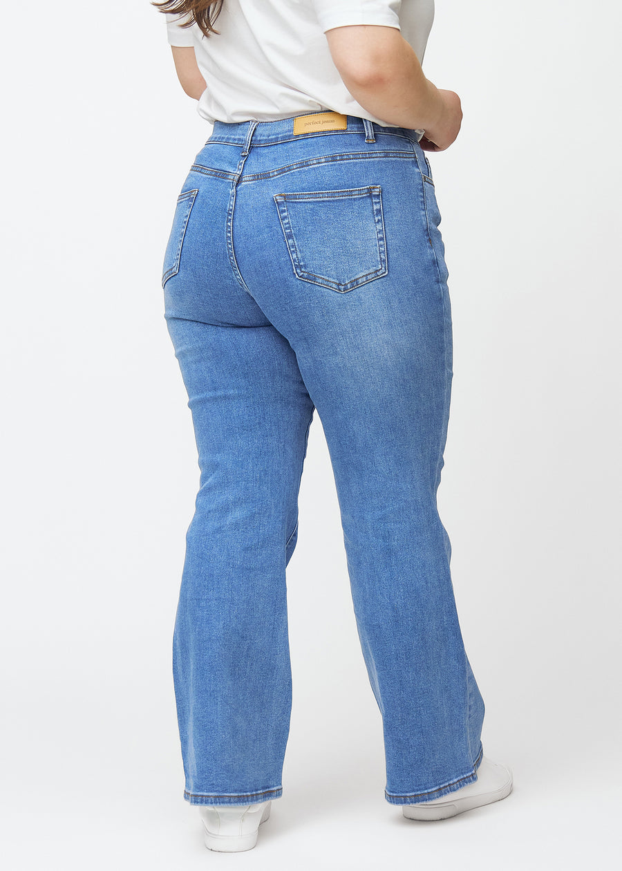 Blå mid-rise bootcut jeans i denimfarven Rivers set bagfra på en plus-size model, så man kan se hele produktet.