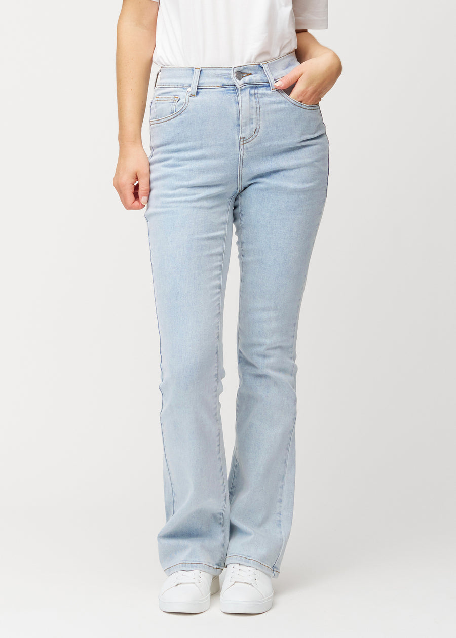 Lyseblå mid-rise bootcut jeans i denimfarven Waves, som sidder tæt fra hofte til lår og har et let svaj forneden, set forfra.