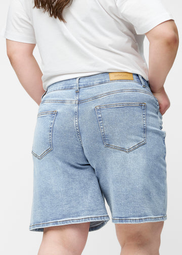 Løse, lyseblå denim shorts i farven Waves set bagfra tæt på på plus-size model for at vise pasform og detaljer.