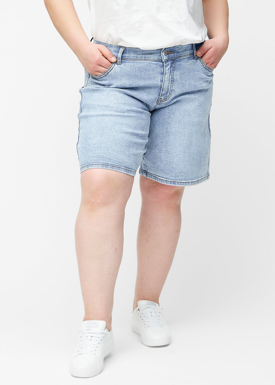 Løse, lyseblå denim shorts i farven Waves set forfra på plus-size model, der sidder til ved hoften og falder løst ned.