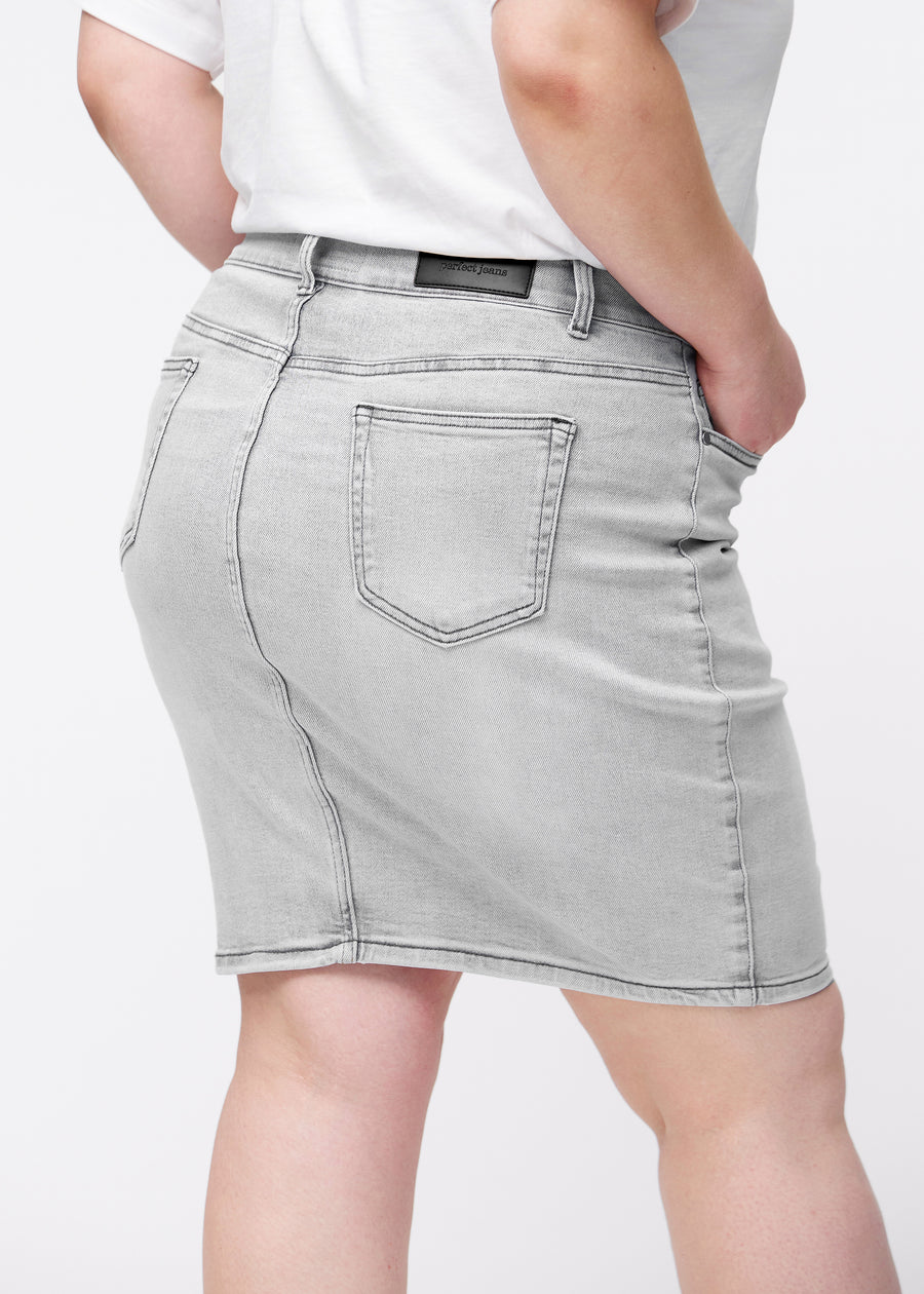 Lysegrå, tætsiddende og knælang denimnederdel set bagfra tæt på på plus-size model for at vise detaljer.