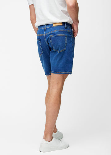 Mørkeblå denim shorts til mænd i farven Oceans set bagfra, så længden til lige over knæet og pasformen kan ses.