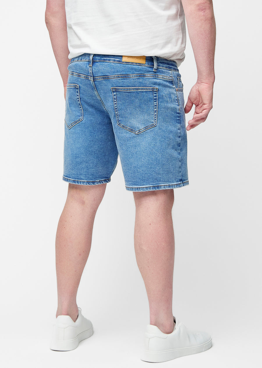 Blå denim shorts til mænd i farven Rivers set bagfra på plus-size model, så længden til lige over knæet kan ses.