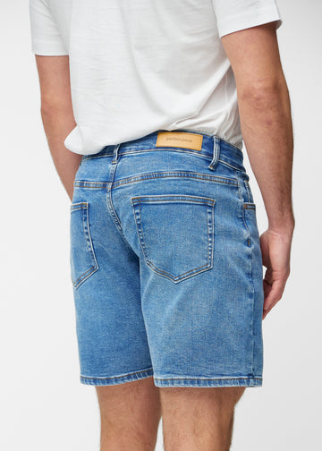 Blå denim shorts til mænd i farven Rivers set bagfra tæt på for at vise pasform og detaljer.
