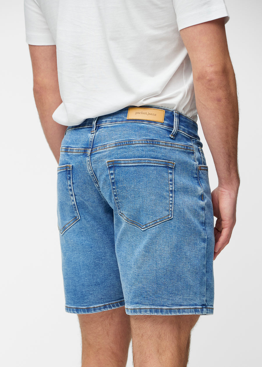 Blå denim shorts til mænd i farven Rivers set bagfra tæt på for at vise pasform og detaljer.
