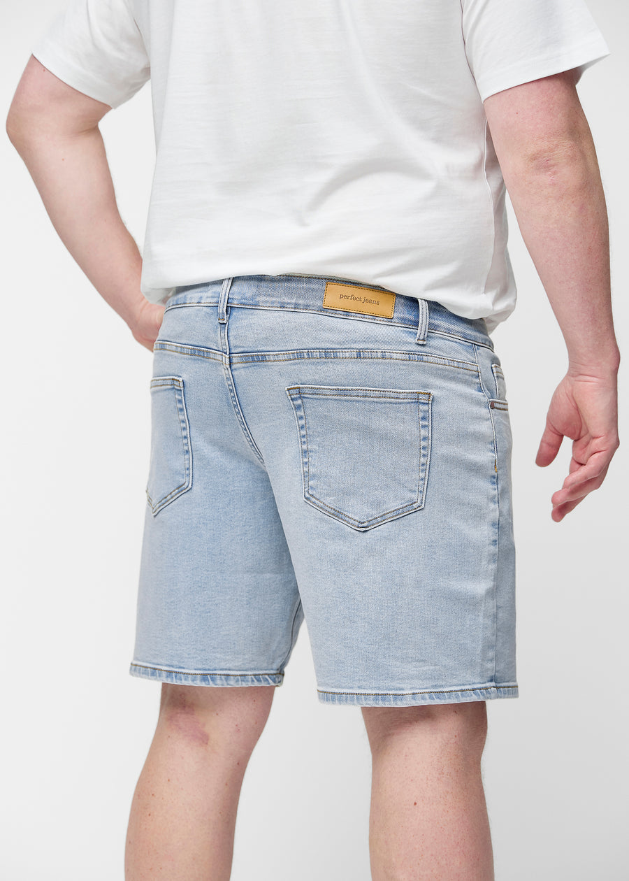 Lyseblå denim shorts til mænd i farven Waves set bagfra tæt på på plus-size model for at vise pasform og detaljer.