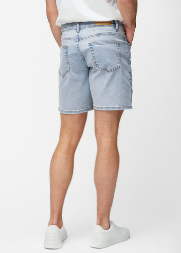 Lyseblå denim shorts til mænd i farven Waves set bagfra, så længden til lige over knæet og pasformen kan ses.