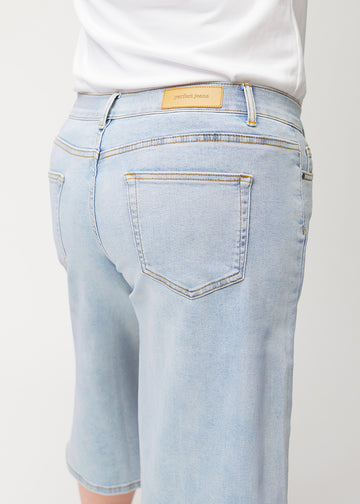 Løse, lyseblå denim capris i farven Waves set bagfra i nærbillede på en plus-size-model for at vise pasform og detaljer.