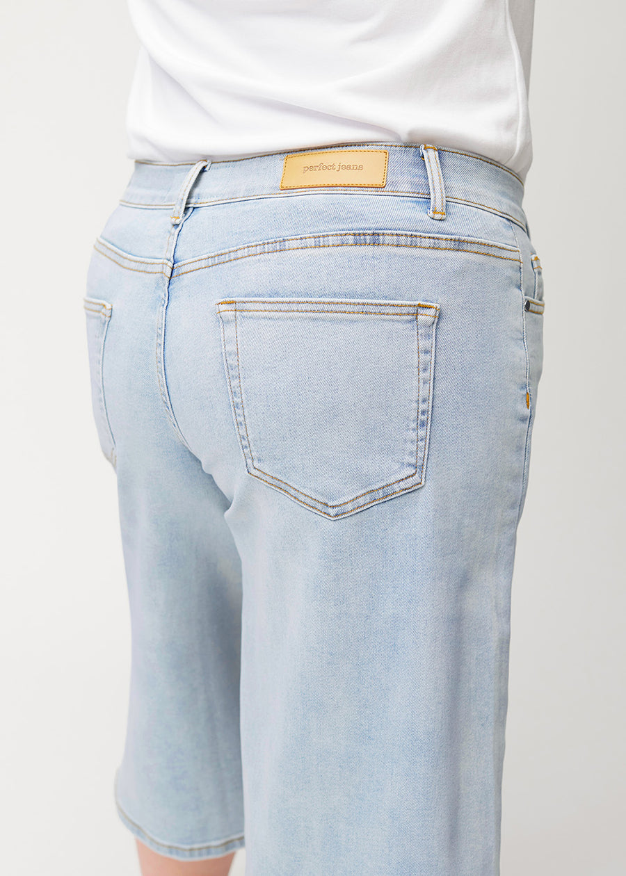 Løse, lyseblå denim capris i farven Waves set bagfra i nærbillede på en plus-size-model for at vise pasform og detaljer.