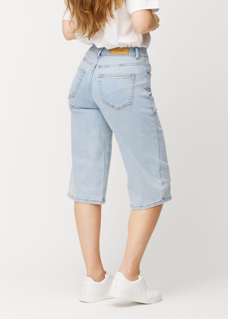 Løse, lyseblå denim capris i farven Waves set bagfra, så pasform og længde kan ses.