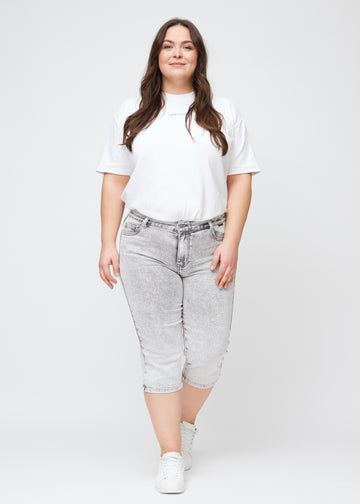 Fuldt billede af en plus-size model i lysegrå denim regular capris.