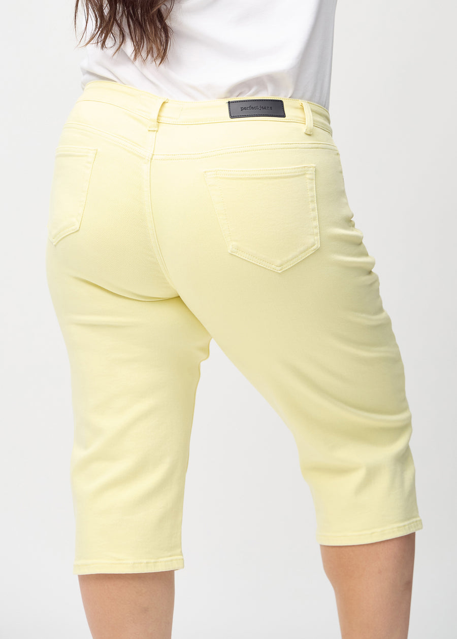 Lysegule regular capris set bagfra tæt på en plus-size model for at vise detaljer.