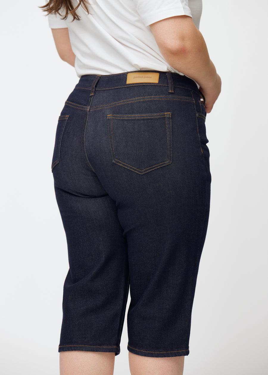 Dyb mørkeblå denim capris til kvinder i farven Midnights set bagfra tæt på på plus-size model.