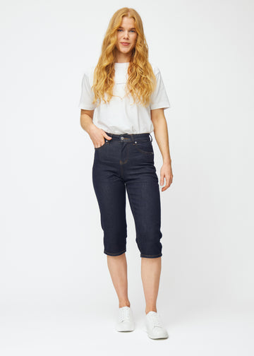 Fuldt billede af model i dyb mørkeblå denim capris til kvinder i farven Midnights med regular pasform.