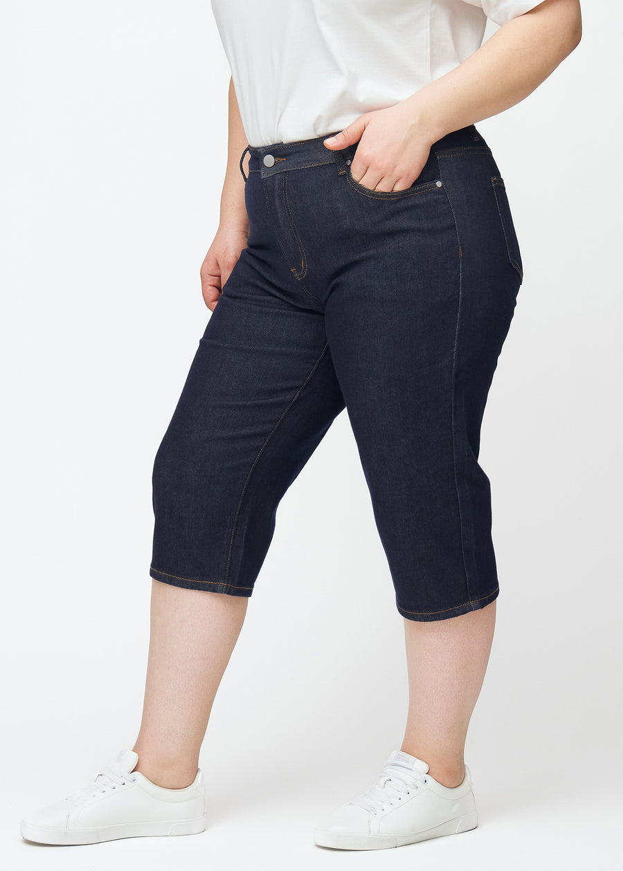 Dyb mørkeblå denim capris til kvinder i farven Midnights med regular pasform set fra siden på plus-size model.