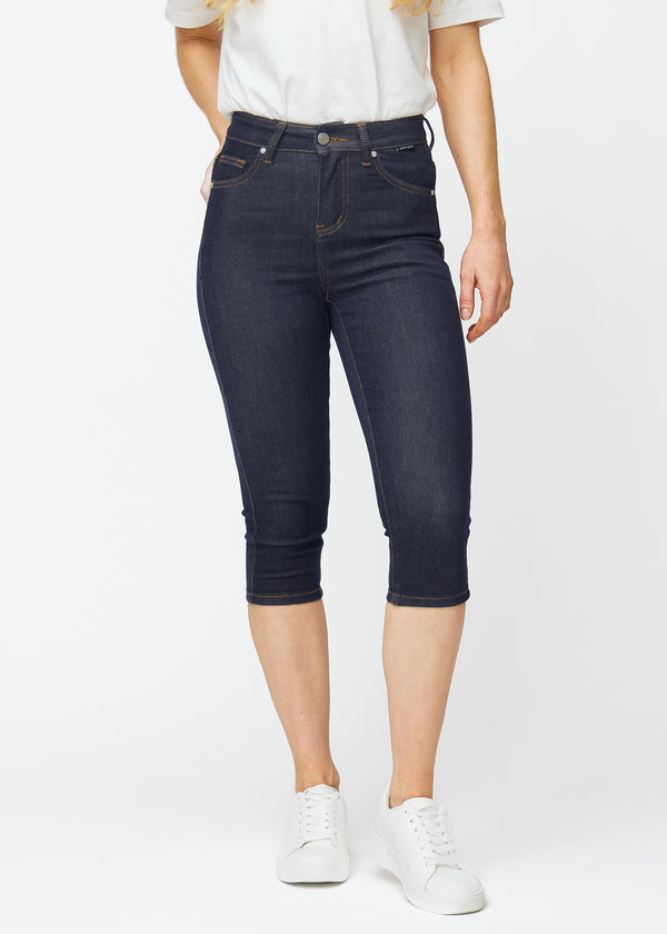 Dyb mørkeblå denim capris til kvinder i farven Midnights med skinny pasform, der sidder tæt fra hofte til under knæ, set forfra.