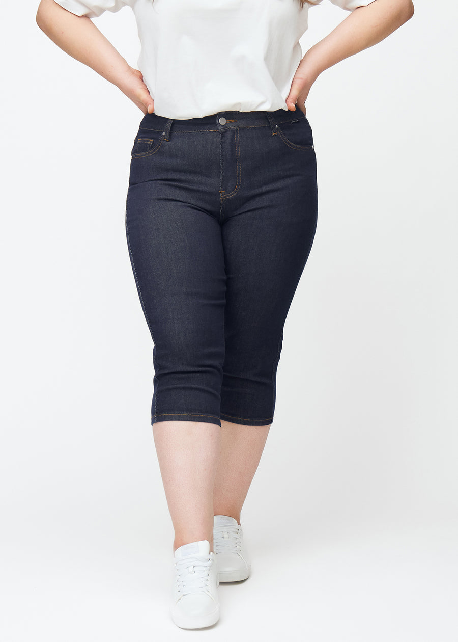 Dyb mørkeblå denim capris til kvinder i farven Midnights med skinny pasform set forfra på plus-size model.