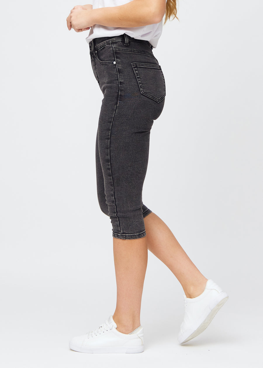 Kvinde iført mørkegrå Shadows denim capris i skinny fit, set fra siden.