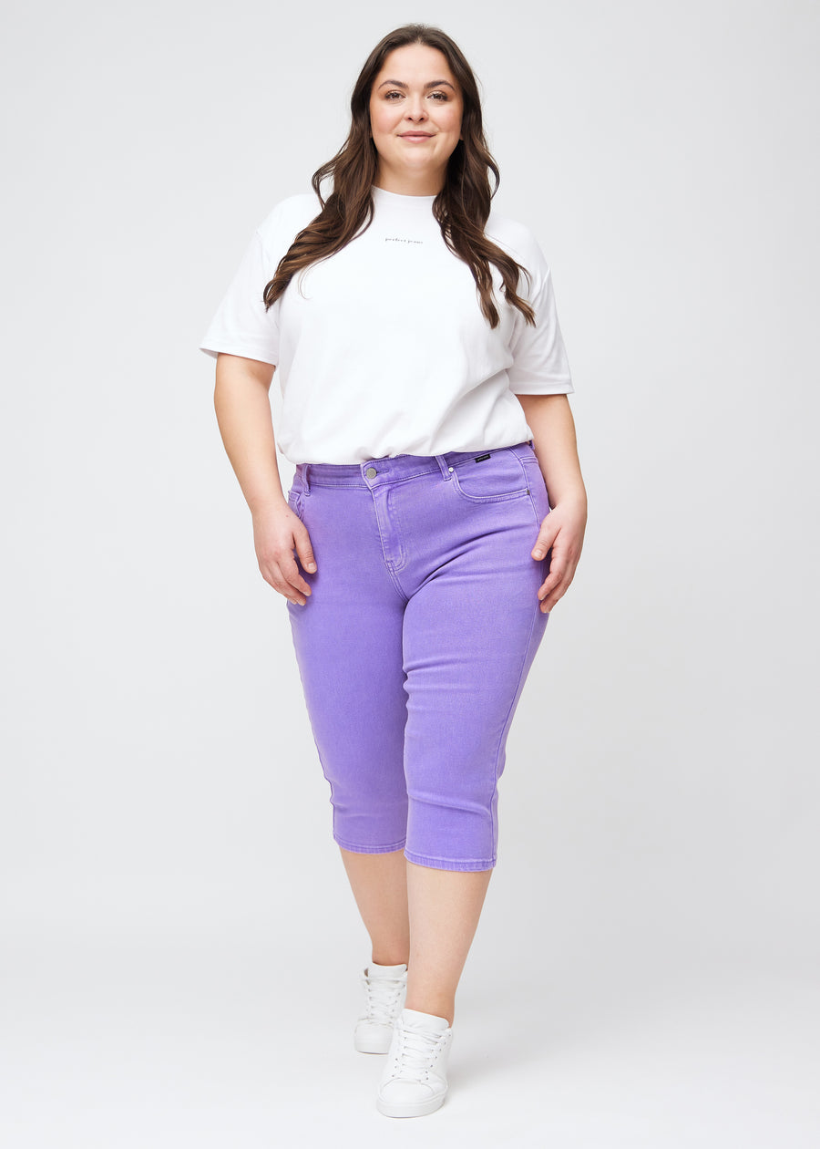 Fuldt billede af plus-size model i lilla slim capris.