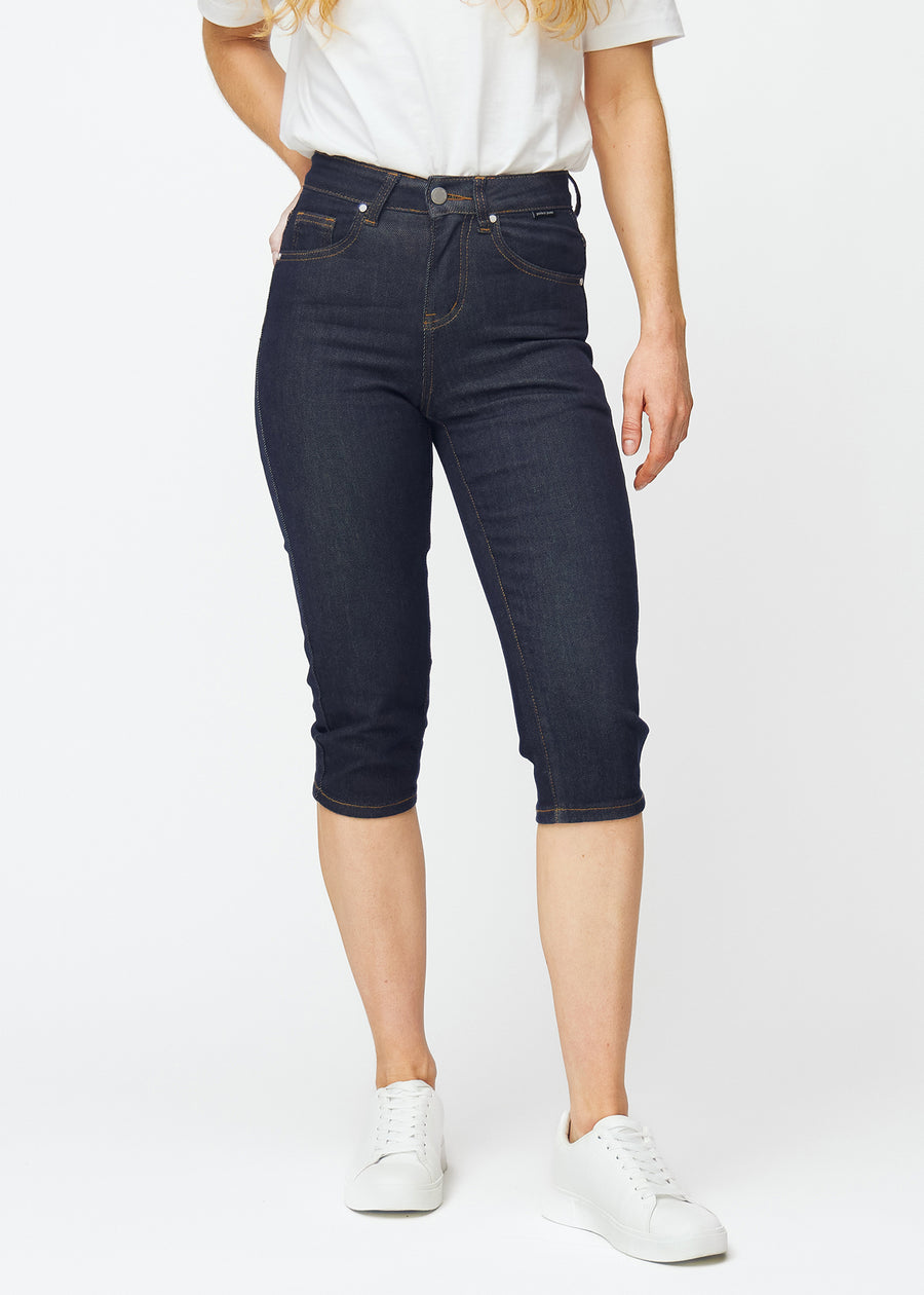 Dyb mørkeblå denim capris til kvinder i farven Midnights med slim pasform, der er figursyet fra hofte til under knæ, set forfra.