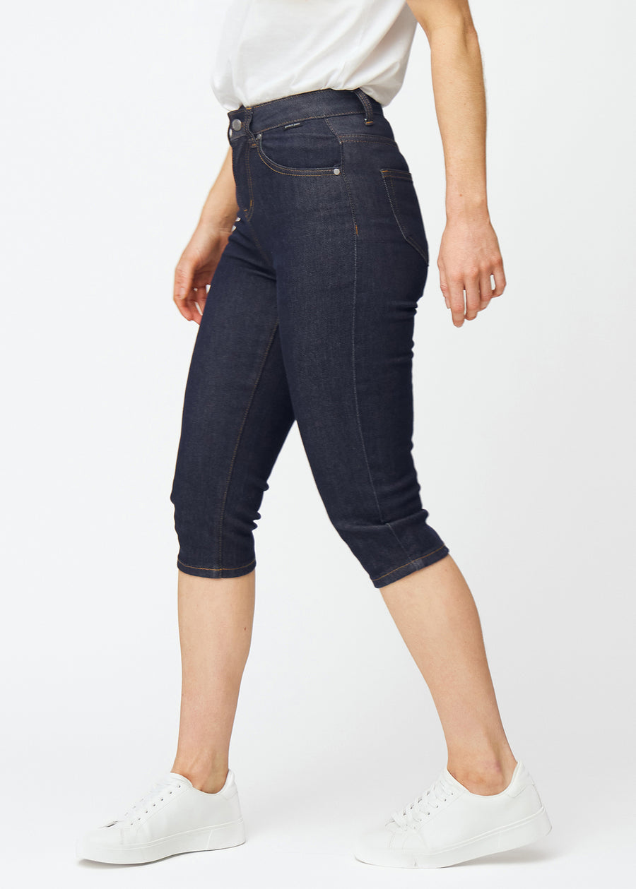 Dyb mørkeblå denim capris til kvinder i farven Midnights med slim pasform set fra siden på model.