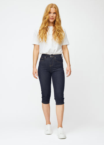 Fuldt billede af model i dyb mørkeblå denim capris til kvinder i farven Midnights med slim pasform.