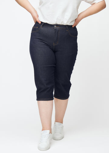 Dyb mørkeblå denim capris til kvinder i farven Midnights med slim pasform set forfra på plus-size model.