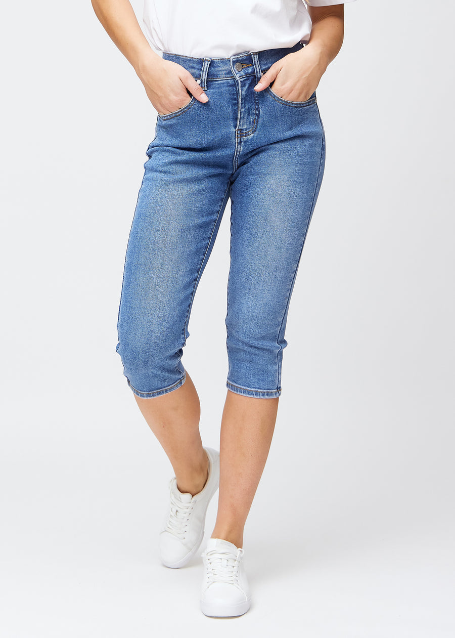 Blå denim slim capris, farve Rivers, med tætsiddende pasform der former benene og slutter lige under knæet – set forfra.