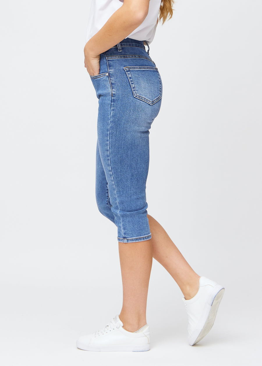 Blå denim slim capris i farven Rivers set fra siden – klassisk pasform med mellemhøj talje og tætsiddende snit.