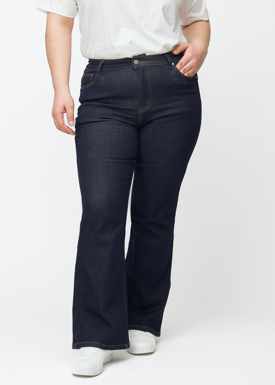 Dyb mørkeblå denim jeans til kvinder i farven Midnights med bootcut pasform set forfra på plus-size model.