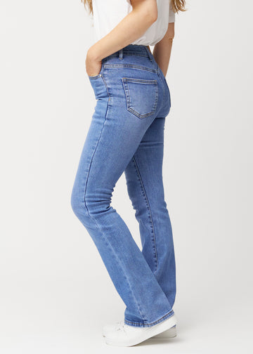 Blå mid-rise bootcut jeans i denimfarven Rivers set fra siden på model.