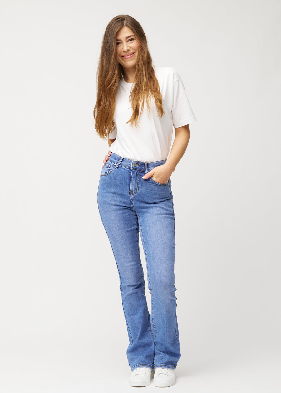 Fuldt billede af model i blå mid-rise bootcut jeans i denimfarven Rivers.