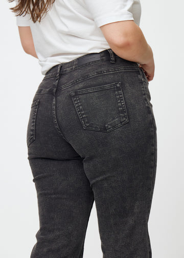 Mørkegrå mid-rise bootcut jeans i denimfarven Shadows set bagfra tæt på en plus-size model for at vise detaljer.
