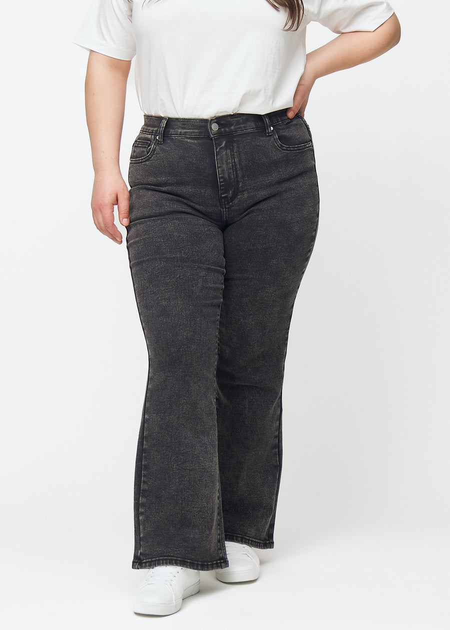 Mørkegrå mid-rise bootcut jeans i denimfarven Shadows, modelnavn Ravens, som sidder tæt fra hofte til lår og har et let svaj forneden, på en plus-size model, set forfra.