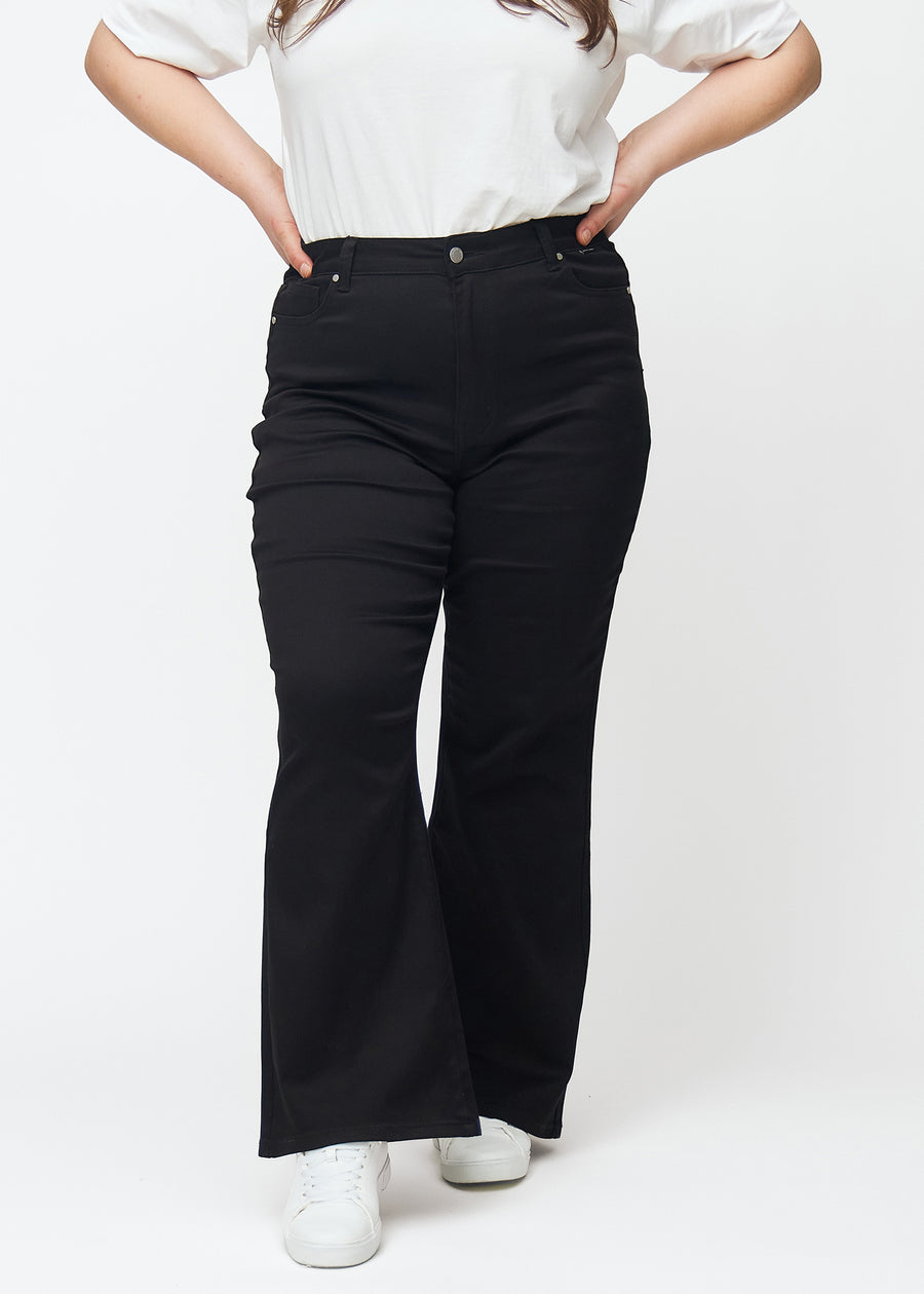 Sorte højtaljede bootcut jeans, modelnavn Ravens, som sidder tæt fra talje til lår og har et let svaj forneden, på en plus-size model, set forfra.