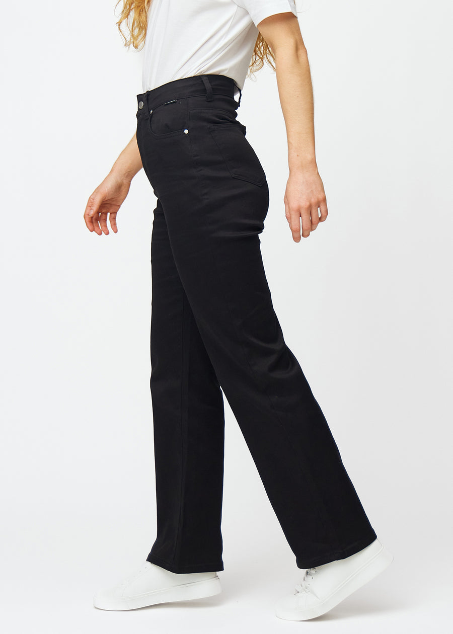 Sorte højtaljede jeans, som sidder til i taljen og har en løs pasform med bredde ned, set fra siden på en model.