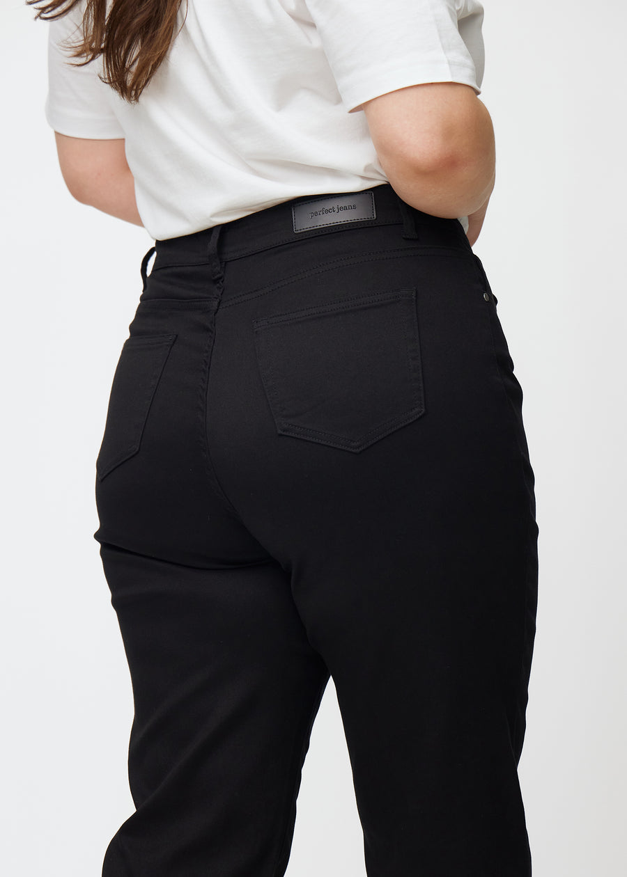 Sorte højtaljede regular jeans set bagfra tæt på en plus-size model for at vise detaljer.